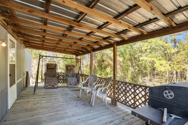 a view of a porch with furniture and wooden floor