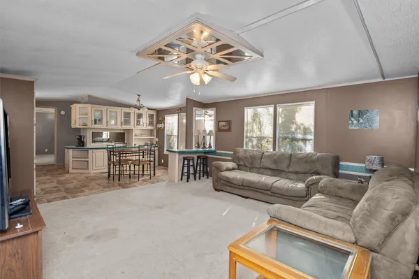 a living room with furniture a chandelier and a dining table