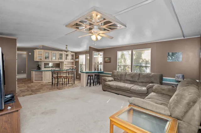 a living room with furniture a chandelier and a dining table