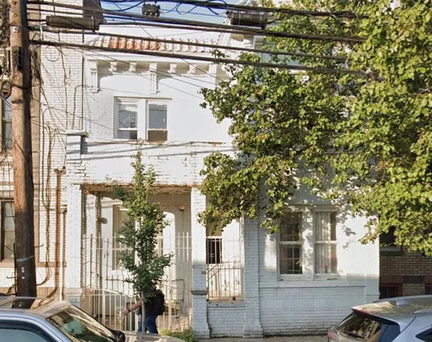 a front view of a building with trees