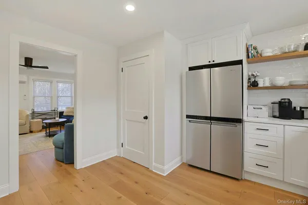 a kitchen with a refrigerator a stove and white cabinets