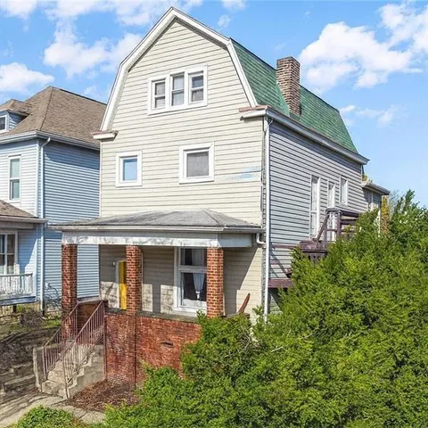 a view of a white house next to a yard