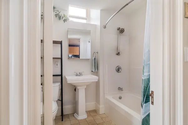 a bathroom with a bathtub a shower a sink and mirror