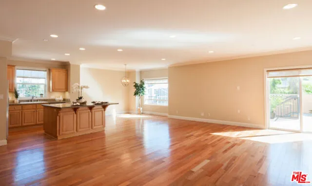 a view of a kitchen with dining table stainless steel appliances and a large window