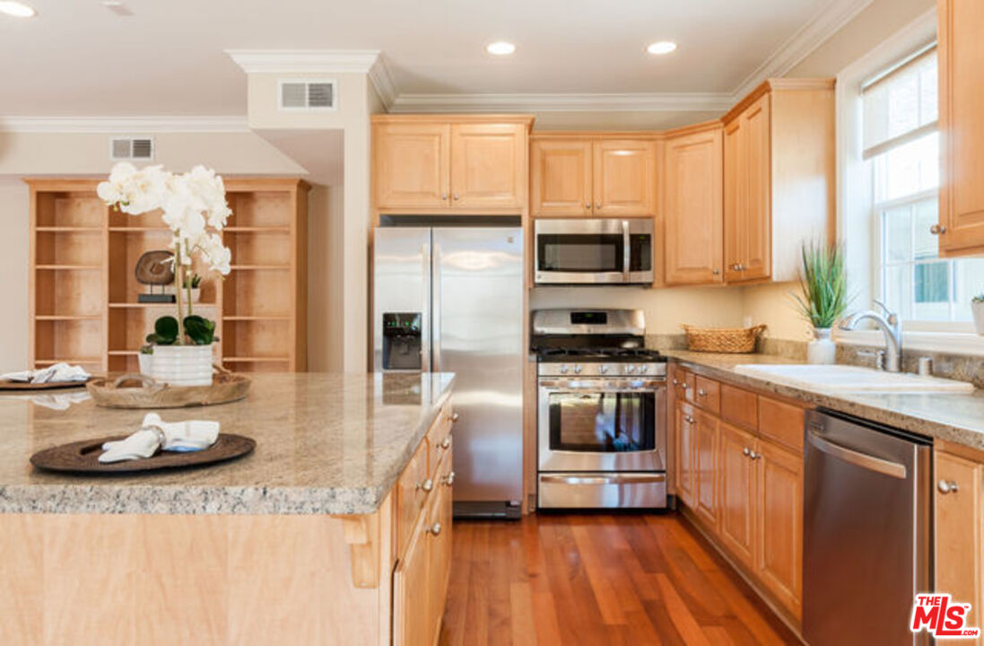 826 Main Street, Unit 6 El Segundo, CA 90245 - Photo 11 of 33 a kitchen with stainless steel appliances kitchen island granite countertop a stove a sink and a refrigerator