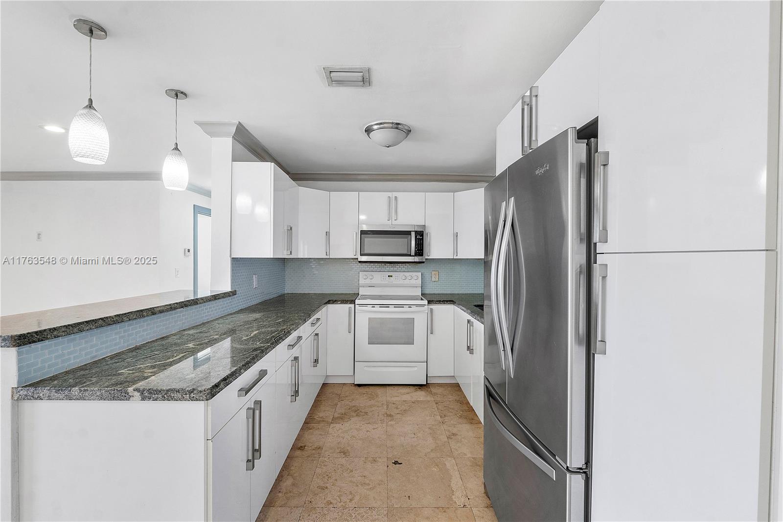 a large kitchen with kitchen island a sink stainless steel appliances and cabinets