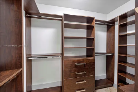a view of walk in closet with empty racks