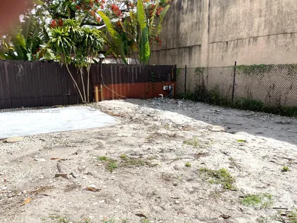 a view of a backyard with wooden fence