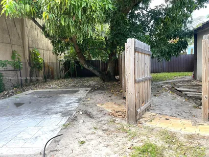 a view of a backyard with couches under an umbrella