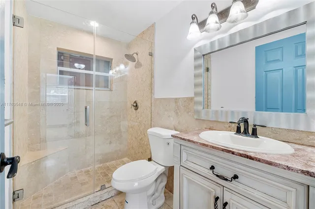 a bathroom with a granite countertop sink toilet and shower