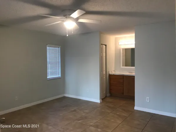 a view of an empty room with window and bathroom