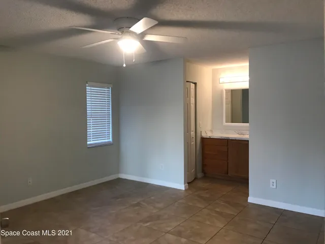 a view of an empty room with window and bathroom