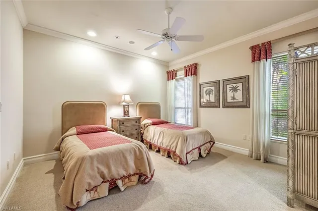 a spacious bedroom with two bed and a chandelier