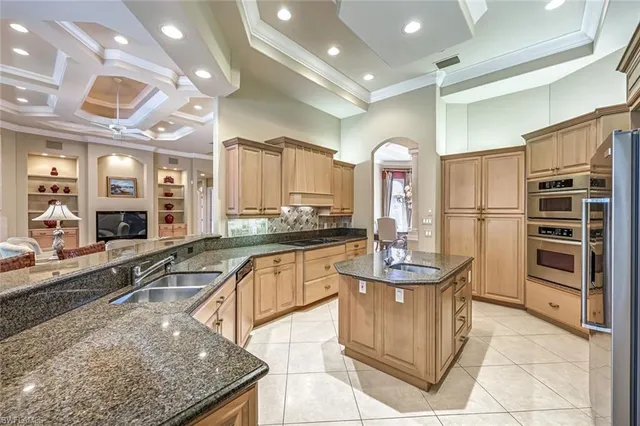 a large kitchen with kitchen island granite countertop a large counter top and stainless steel appliances
