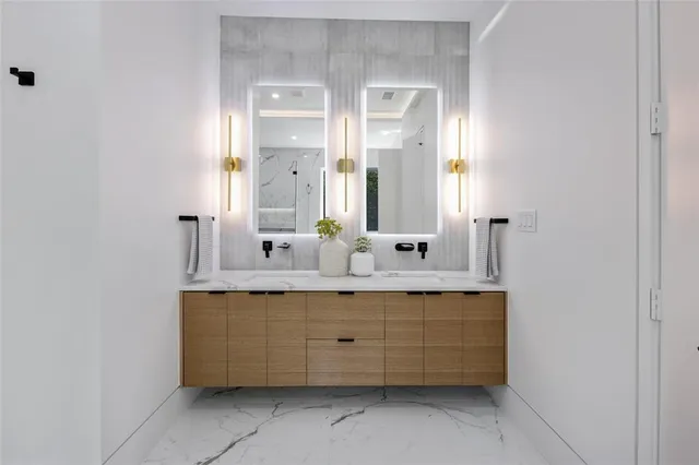 a bathroom with a double vanity sink mirror and shower