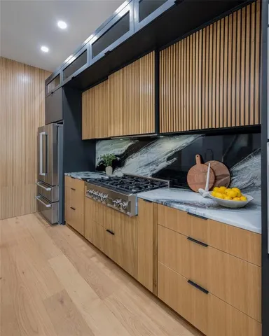a kitchen with stainless steel appliances kitchen island granite countertop a sink and a refrigerator