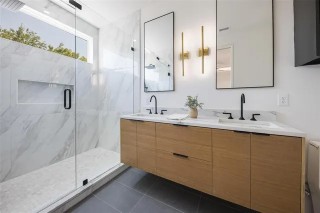 a bathroom with a double vanity sink mirror and shower