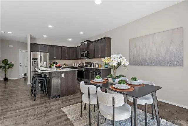 a dining room filled chandelier and wooden floor
