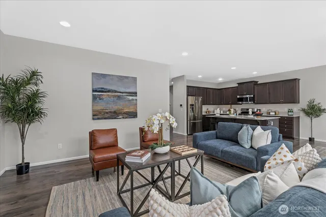 a living room with furniture and a wooden floor