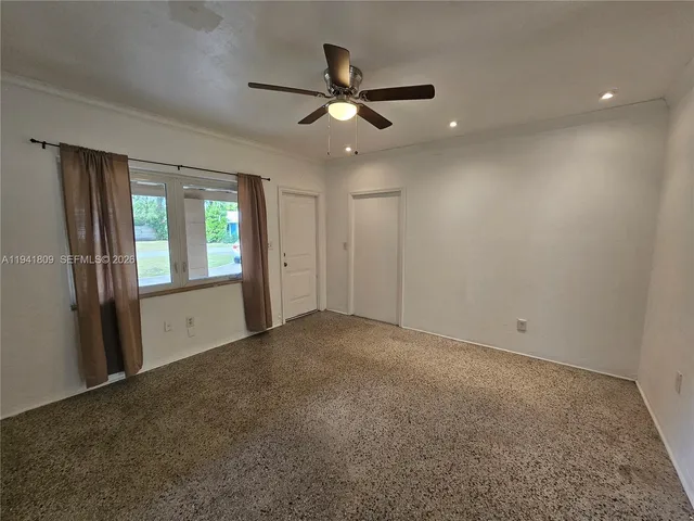 an empty room with closet and windows