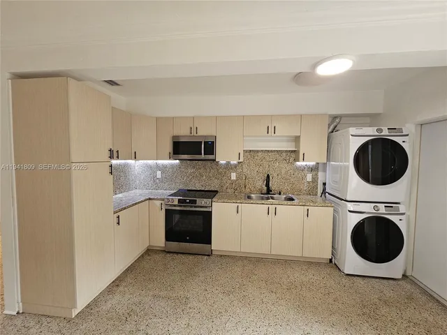 a kitchen with stainless steel appliances granite countertop a refrigerator a stove top oven and sink