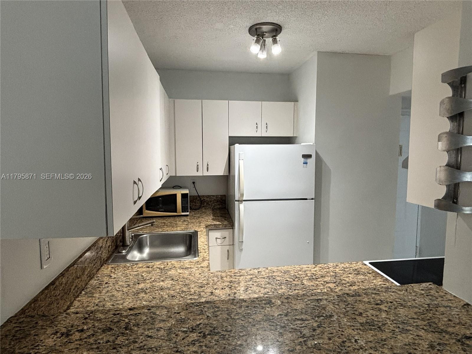 126 Southwest 17th Road, Unit 505 Miami, FL 33129 - Photo 14 of 27 a kitchen that has a refrigerator a stove a sink and a counter top space