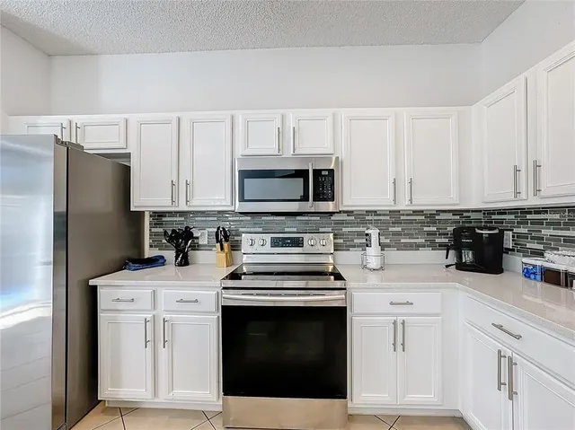 a kitchen with white cabinets and stainless steel appliances