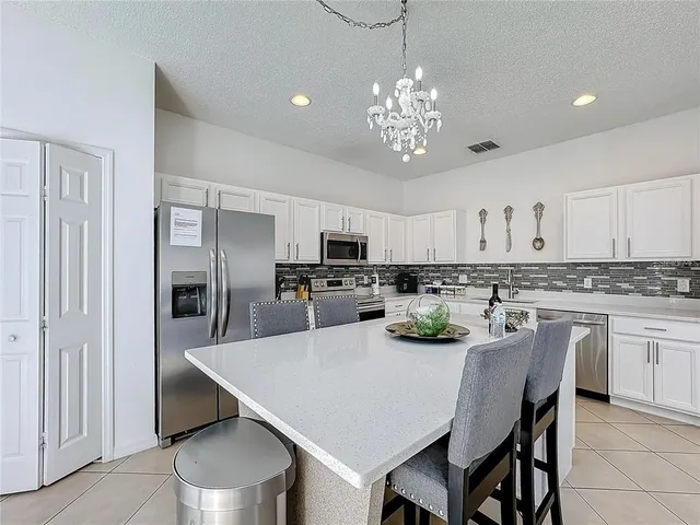 a kitchen with stainless steel appliances a table and chairs in it