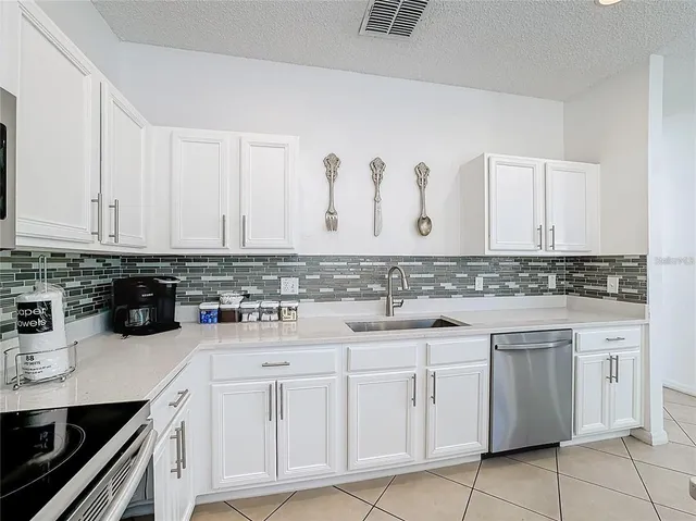 a kitchen with white cabinets appliances and sink