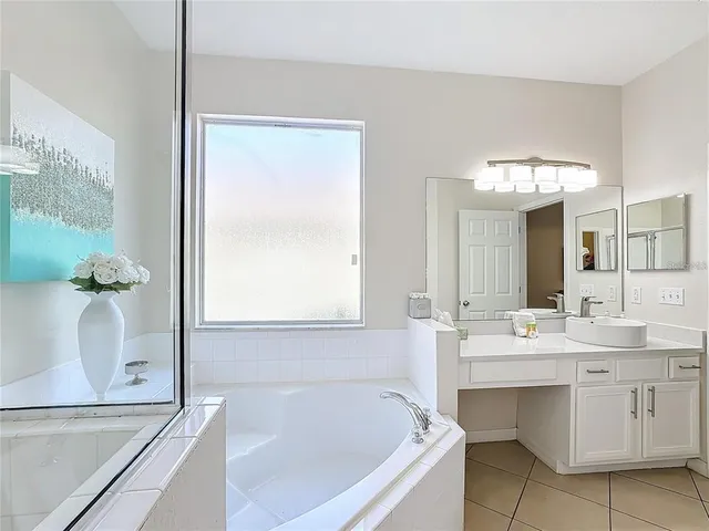 a bathroom with a tub sink and mirror