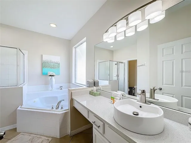 a bathroom with a double vanity sink mirror and bathtub