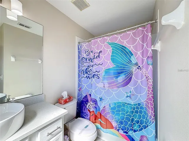 a bathroom with a sink toilet and shower curtain