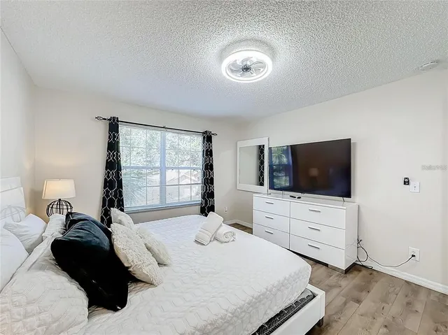 a bedroom with a bed and flat screen tv