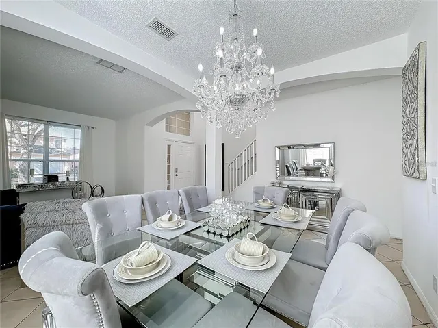 a dining room with furniture a chandelier and window