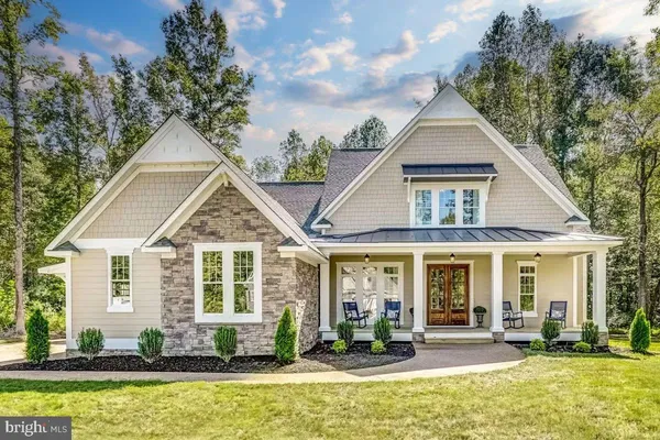 a front view of a house with swimming pool and porch with furniture