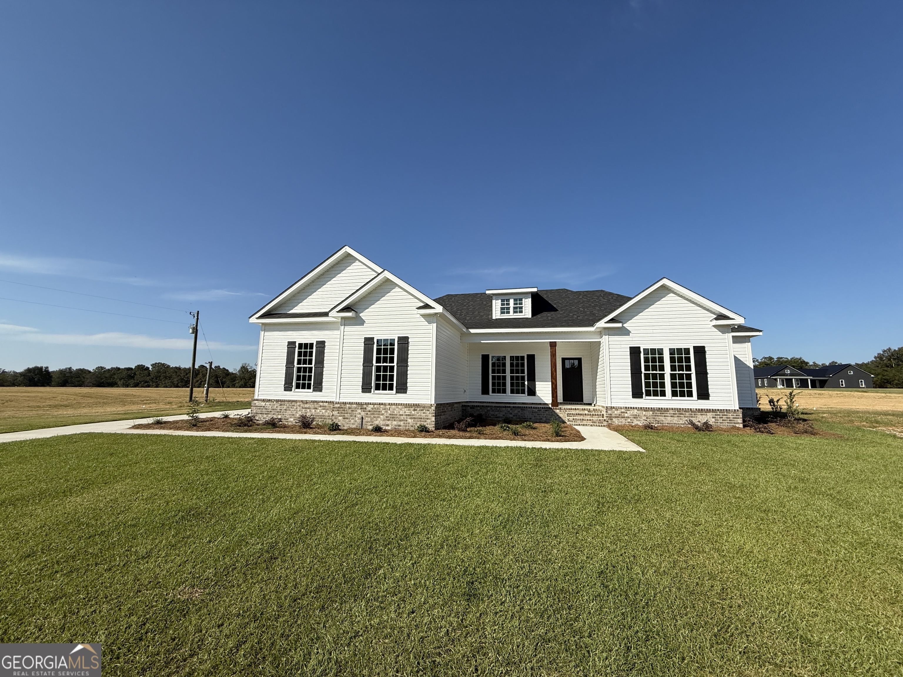 a front view of a house with a garden and yard