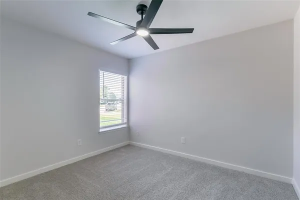 an empty room with window and fan