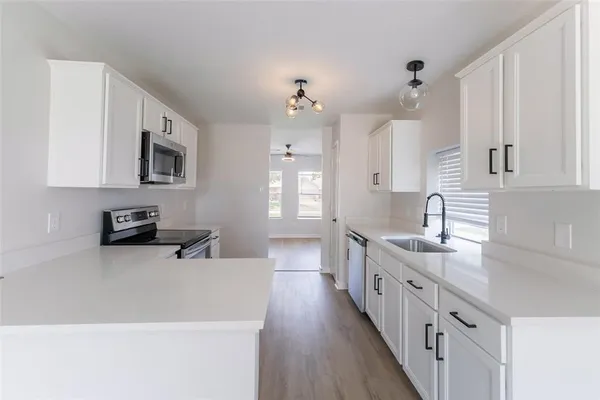 a kitchen with sink a stove and cabinets