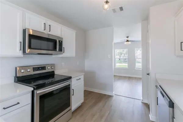 a kitchen with granite countertop a stove and a microwave