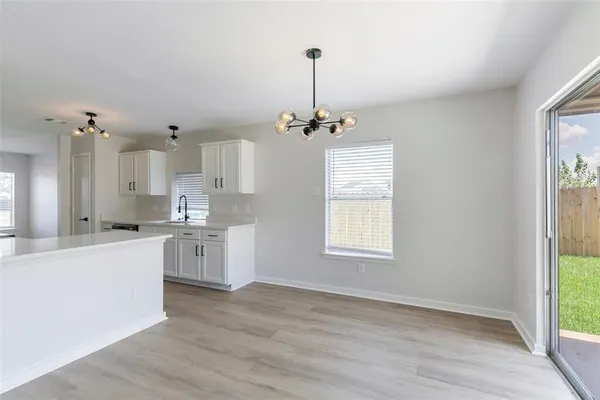a large kitchen with kitchen island a white counter space a sink and a window