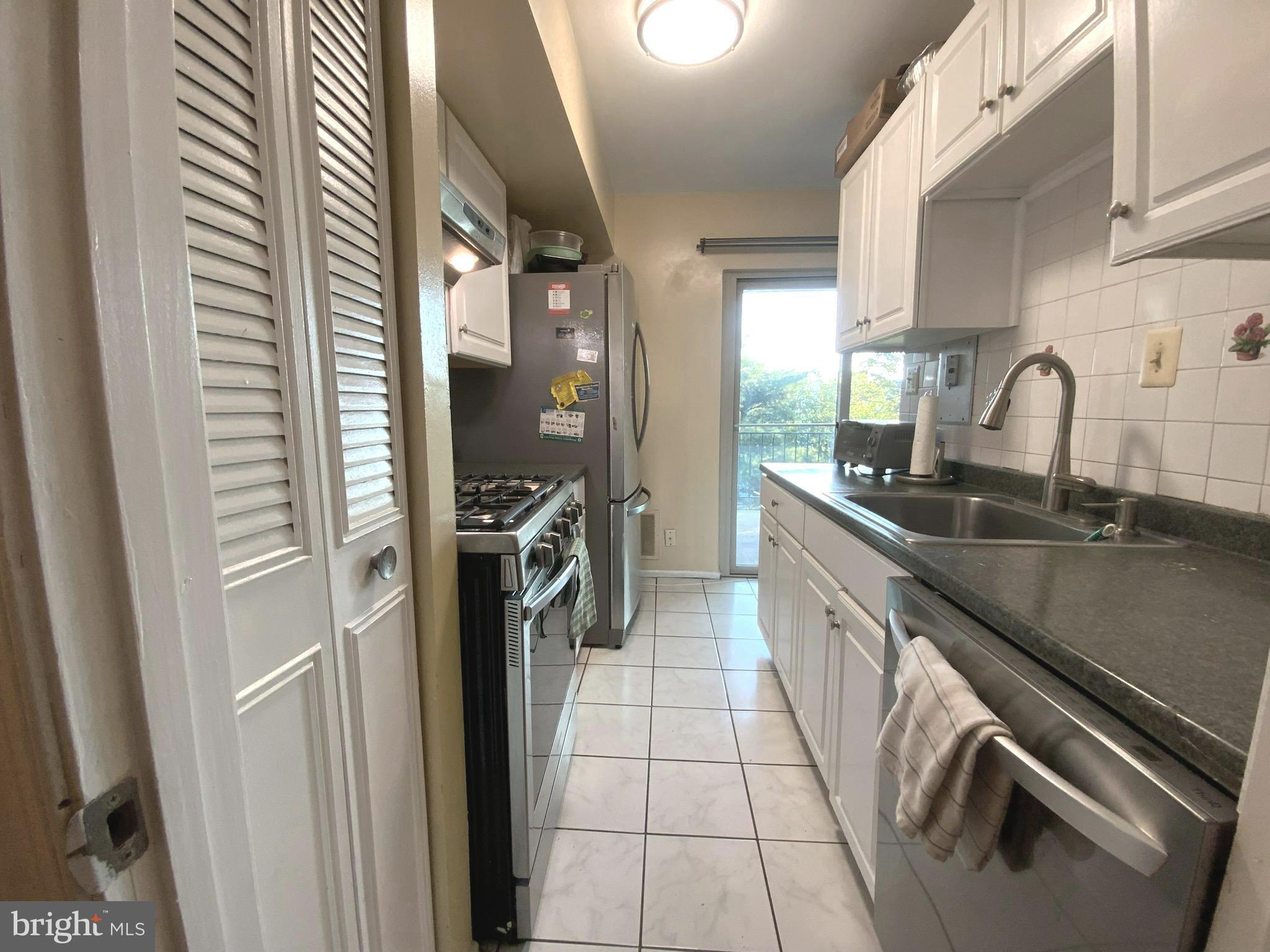 2302 Greenery Lane, Unit 30116 Silver Spring, MD 20906 - Photo 14 of 34 a kitchen with a sink stainless steel appliances a counter space and a window