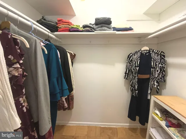 a view of walk in closet with clothes and shoes