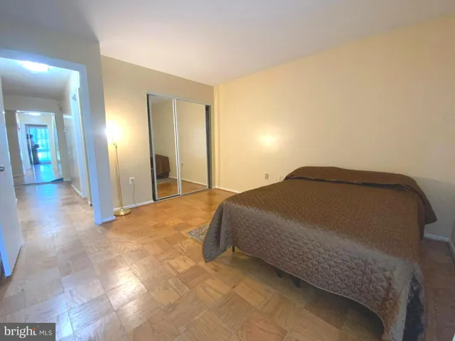 a bedroom with a bed and painting on the wall