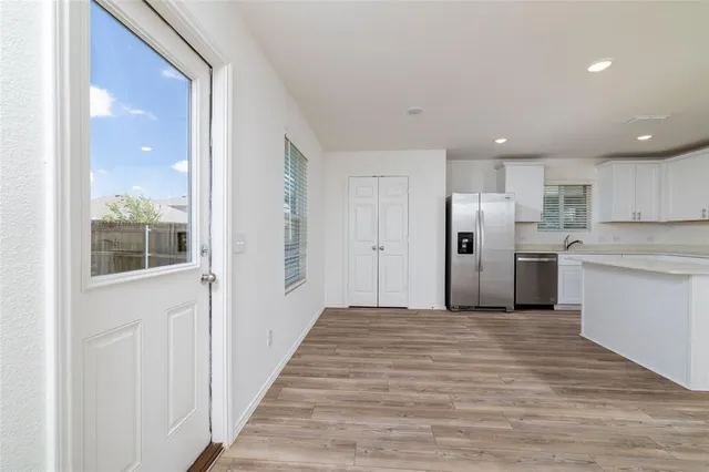 a view of a kitchen with refrigerator and white cabinets