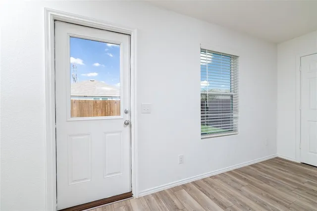 a view of an empty room with closet and a window