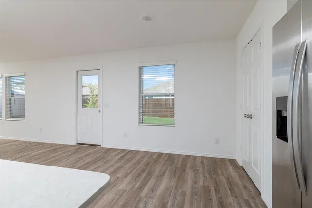 an empty room with wooden floor and a bathroom
