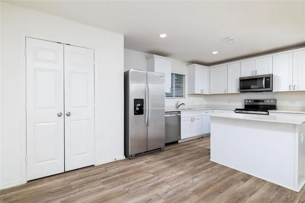 a kitchen with a refrigerator a sink and a microwave