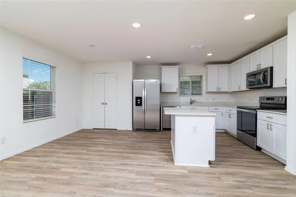 a kitchen with stainless steel appliances granite countertop a stove a sink and a refrigerator