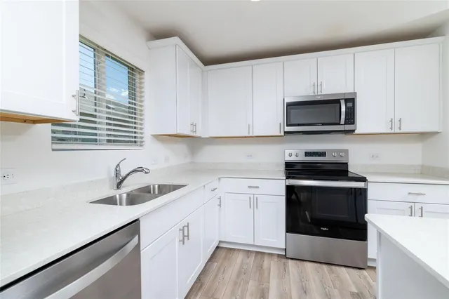 a kitchen with cabinets stainless steel appliances a sink and a counter space