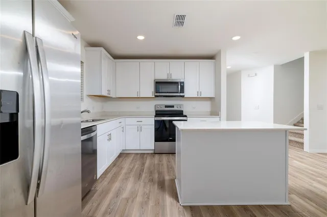 a kitchen with wooden cabinets and stainless steel appliances